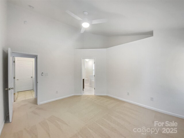 carpeted empty room featuring ceiling fan and high vaulted ceiling