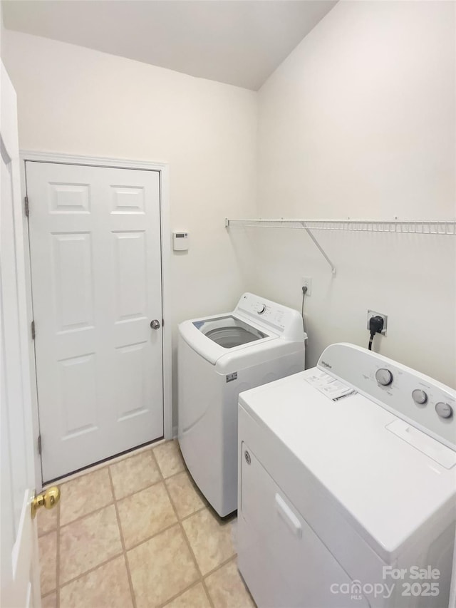 laundry area with light tile patterned flooring and washer and dryer