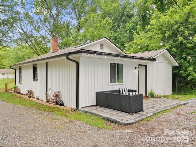 rear view of property featuring an outdoor living space and a patio