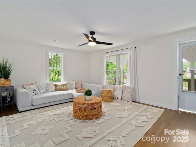 living room featuring dark hardwood / wood-style flooring and ceiling fan