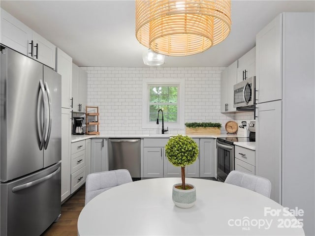 kitchen featuring white cabinetry, appliances with stainless steel finishes, sink, and decorative backsplash