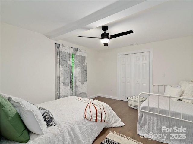 bedroom featuring a closet, beamed ceiling, dark hardwood / wood-style floors, and ceiling fan