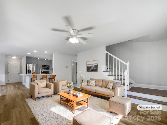 living room featuring ceiling fan and dark hardwood / wood-style flooring