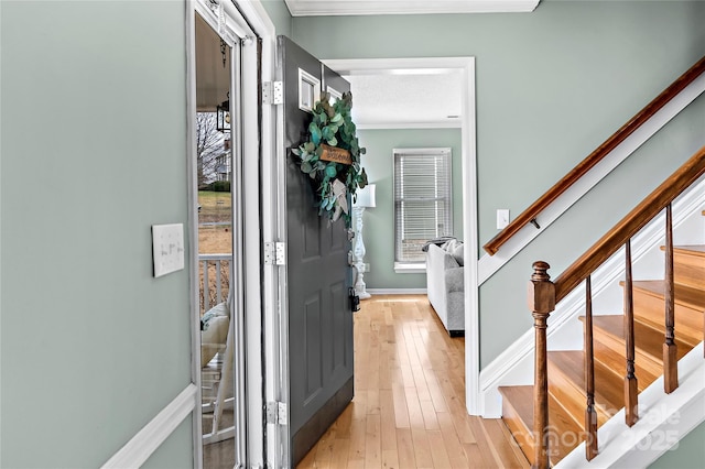 entrance foyer featuring ornamental molding and light wood-type flooring