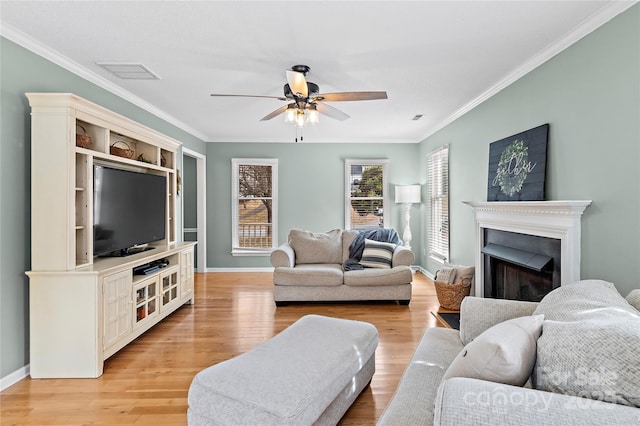 living room with crown molding, ceiling fan, and light wood-type flooring