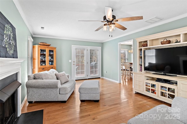 living room featuring ceiling fan, ornamental molding, and light hardwood / wood-style floors