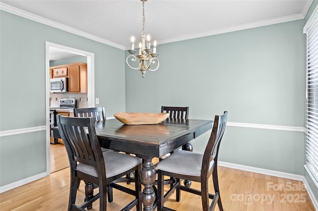 dining area with a notable chandelier, crown molding, and light hardwood / wood-style floors