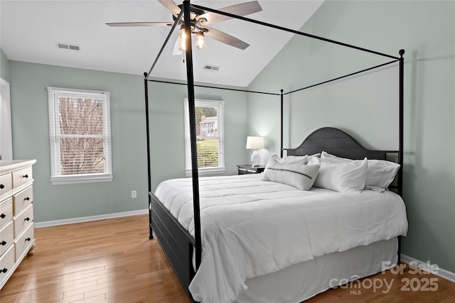 bedroom with ceiling fan, lofted ceiling, and light wood-type flooring