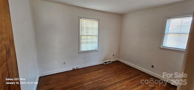 spare room with dark wood-type flooring