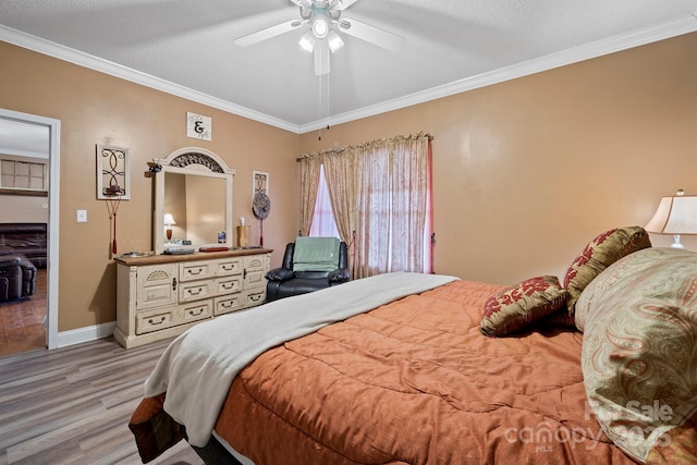 bedroom featuring ceiling fan, crown molding, light hardwood / wood-style flooring, and a textured ceiling