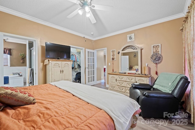 bedroom featuring a walk in closet, ceiling fan, crown molding, a textured ceiling, and a closet