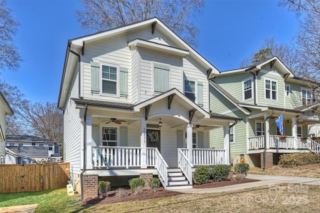 view of front of home with a ceiling fan, covered porch, and fence