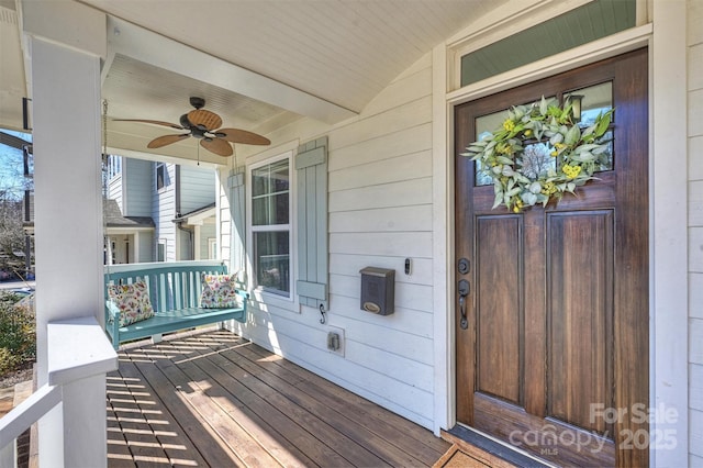 entrance to property with ceiling fan and a porch