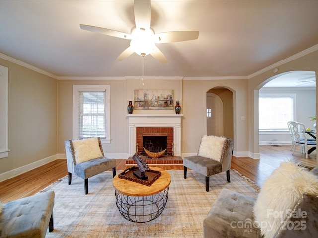 living room featuring ornamental molding, a fireplace, and light wood-type flooring