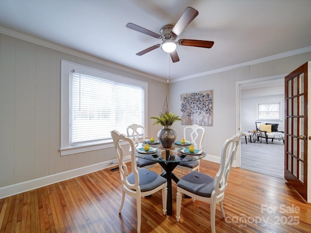 dining space with crown molding, a healthy amount of sunlight, and light hardwood / wood-style floors