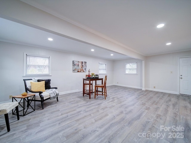 living area with ornamental molding and light wood-type flooring