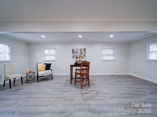 living area featuring crown molding and light hardwood / wood-style flooring