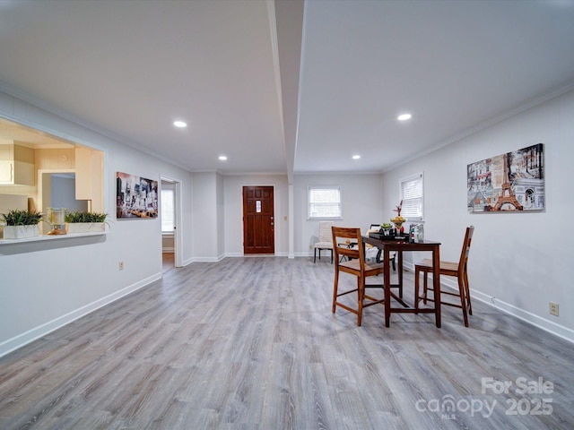 dining space with crown molding and light hardwood / wood-style floors