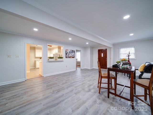 dining area with crown molding and light hardwood / wood-style flooring