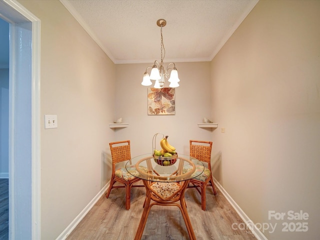 dining room with ornamental molding, a textured ceiling, an inviting chandelier, and light hardwood / wood-style flooring