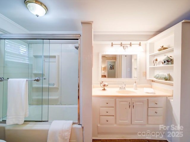 bathroom featuring crown molding, enclosed tub / shower combo, and vanity