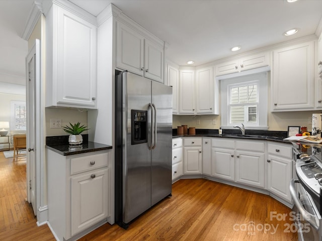 kitchen with white cabinetry, appliances with stainless steel finishes, sink, and light wood-type flooring