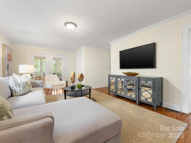 living room featuring hardwood / wood-style flooring, ornamental molding, and french doors