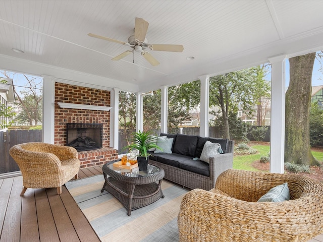 sunroom featuring an outdoor brick fireplace, ceiling fan, and a wealth of natural light