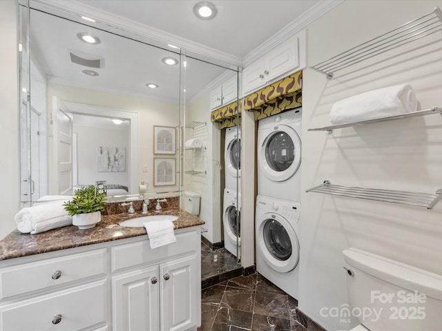 clothes washing area featuring stacked washer / drying machine, crown molding, and sink