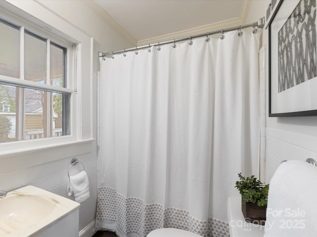 bathroom featuring crown molding, tile walls, vanity, and toilet