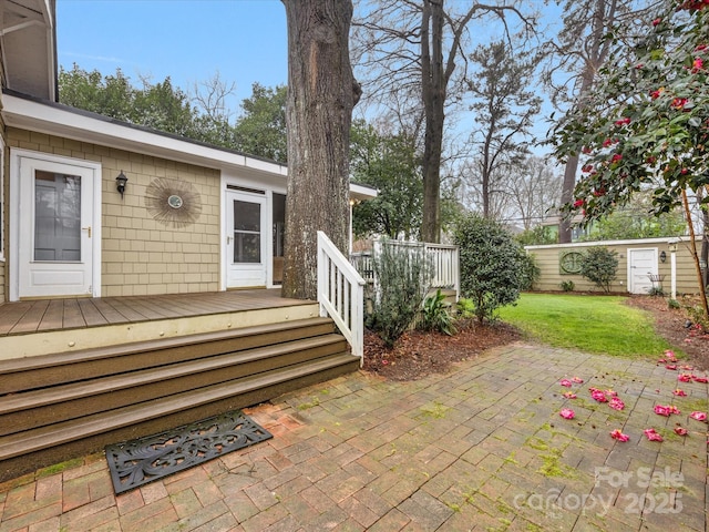 wooden terrace featuring a yard and a patio