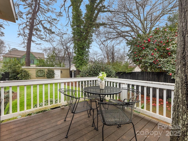 wooden terrace with an outbuilding and a lawn