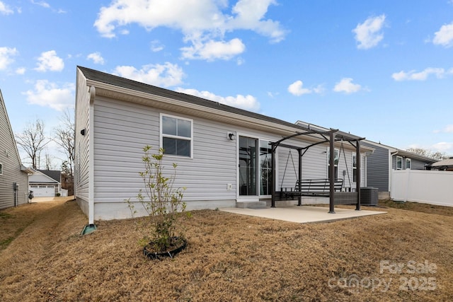 rear view of property with cooling unit, a pergola, a patio, and a lawn