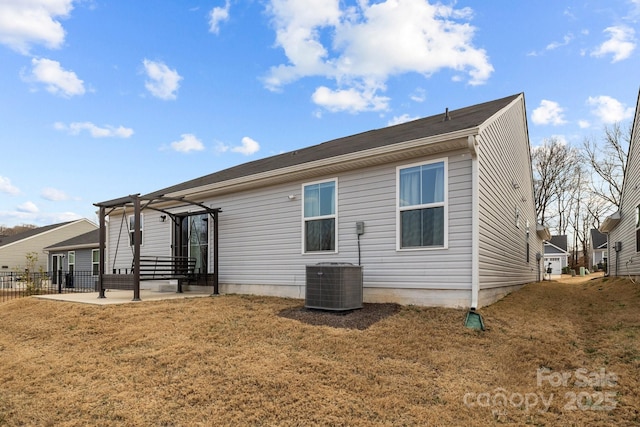 rear view of property with a yard, central AC, and a patio area