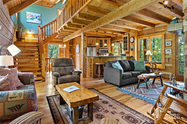 living room with beamed ceiling, wooden ceiling, a notable chandelier, and light wood-type flooring