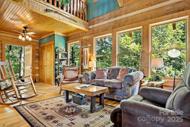 living room with ceiling fan, wood ceiling, plenty of natural light, and wood-type flooring