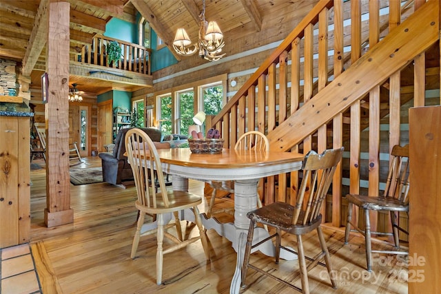 dining space featuring high vaulted ceiling, ceiling fan with notable chandelier, wooden ceiling, beamed ceiling, and light wood-type flooring