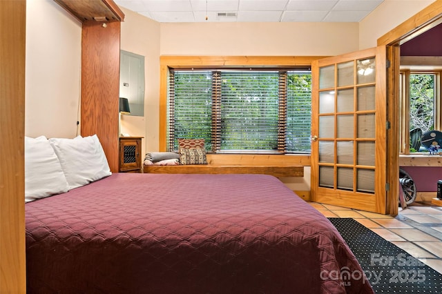 tiled bedroom featuring a paneled ceiling and a fireplace