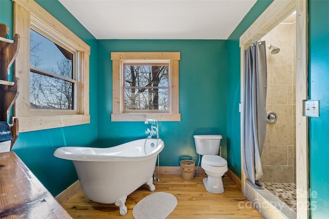 bathroom with hardwood / wood-style flooring, shower with separate bathtub, and toilet