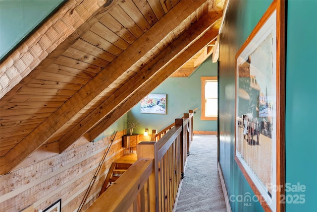 hall with vaulted ceiling with beams, wood ceiling, and carpet flooring