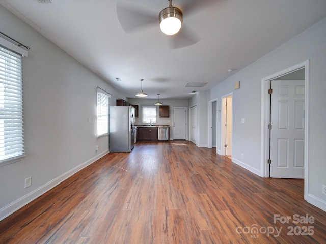 unfurnished living room with ceiling fan, dark hardwood / wood-style flooring, and sink