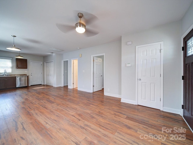 unfurnished living room with hardwood / wood-style flooring, sink, and ceiling fan