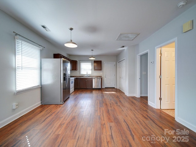 kitchen with pendant lighting, appliances with stainless steel finishes, dark hardwood / wood-style floors, and sink