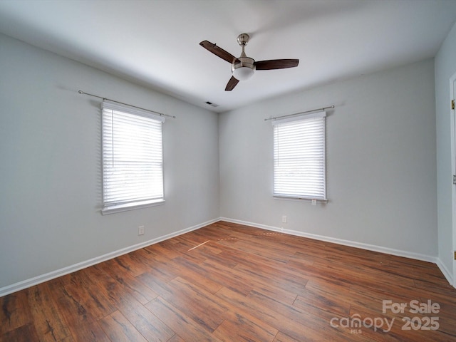 spare room with ceiling fan, plenty of natural light, and dark hardwood / wood-style flooring