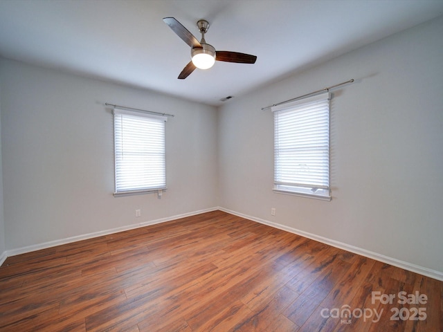 empty room with ceiling fan and dark hardwood / wood-style flooring