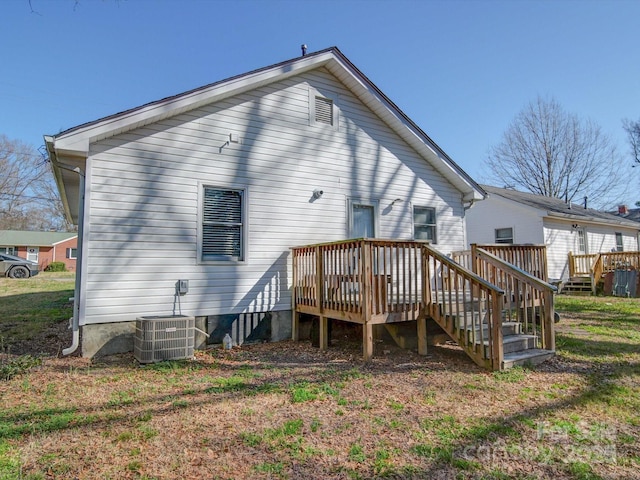 back of property featuring a lawn, a deck, and central air condition unit