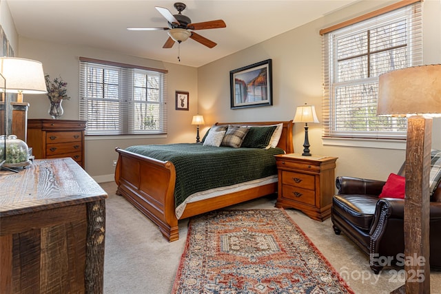 carpeted bedroom featuring multiple windows and ceiling fan