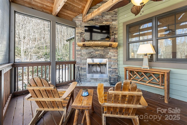 sunroom featuring vaulted ceiling with beams, wooden ceiling, and a fireplace