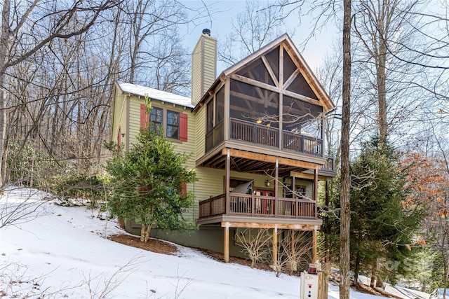 snow covered house featuring ceiling fan