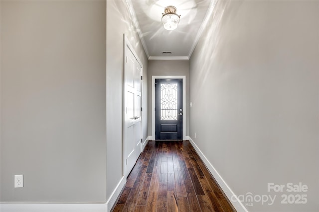 doorway to outside featuring baseboards, dark wood-style flooring, visible vents, and crown molding